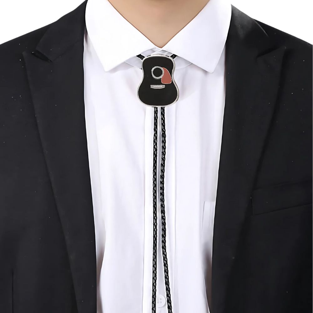 Black guitar bolo tie worn over a white shirt and dark jacket